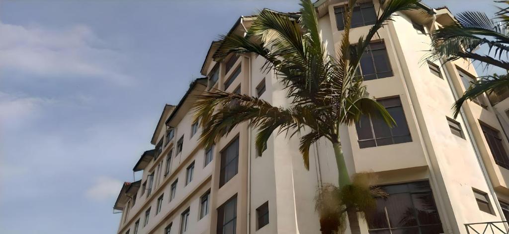 ein hohes Gebäude mit einer Palme davor in der Unterkunft Plus254 Hotel in Nairobi