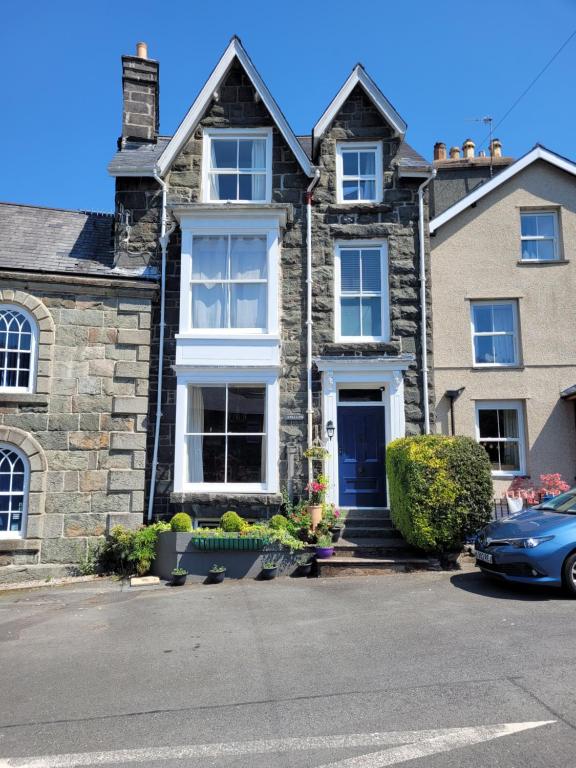 ドルゲラウにあるAfallon Townhouse Gwynedd Roomの青い扉付きの大きな石造りの家