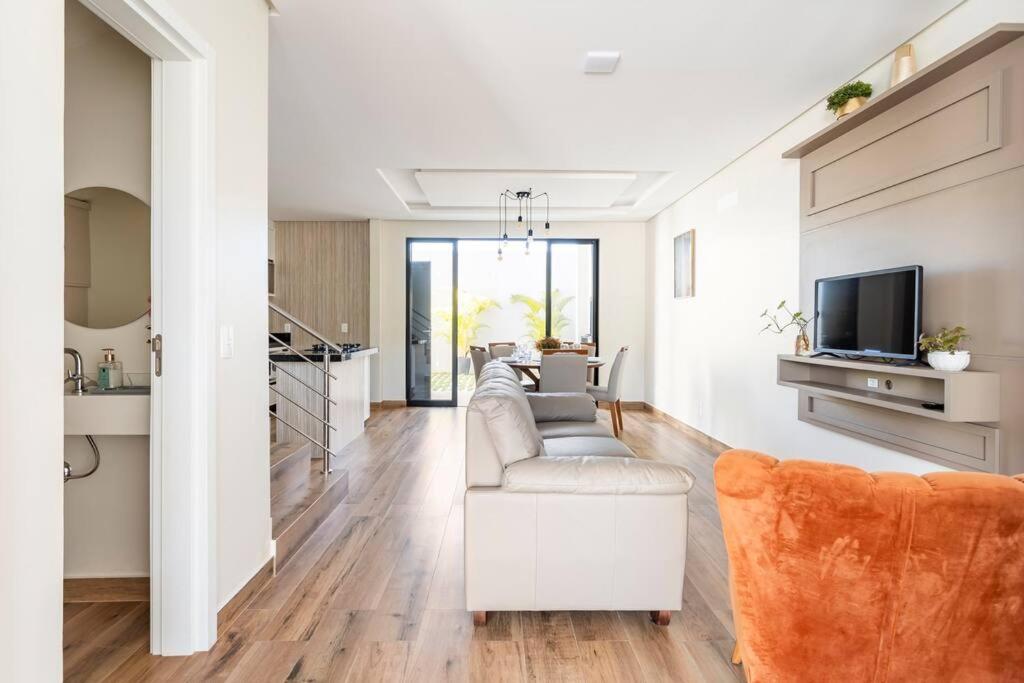 ein Wohnzimmer mit Sofa und Fernseher in der Unterkunft Casa Neves em Bombas in Bombinhas