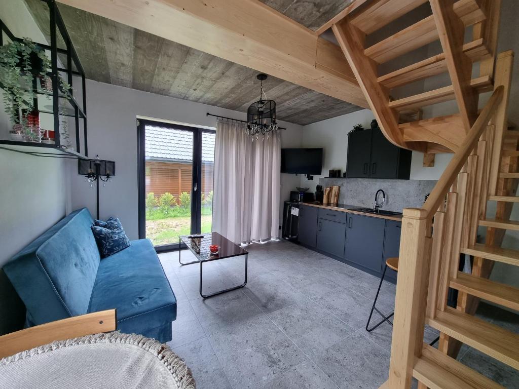 a living room with a blue couch and a kitchen at Apartament Na Kamieńcu w Dolinie Dunajca nr 1 in Tylmanowa
