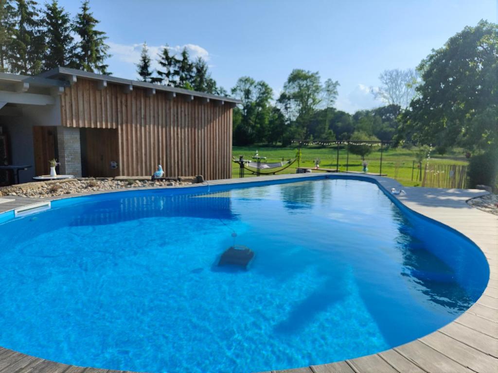 a large blue swimming pool with a wooden deck at Ferienhaus im Wesenitztal in Stolpen