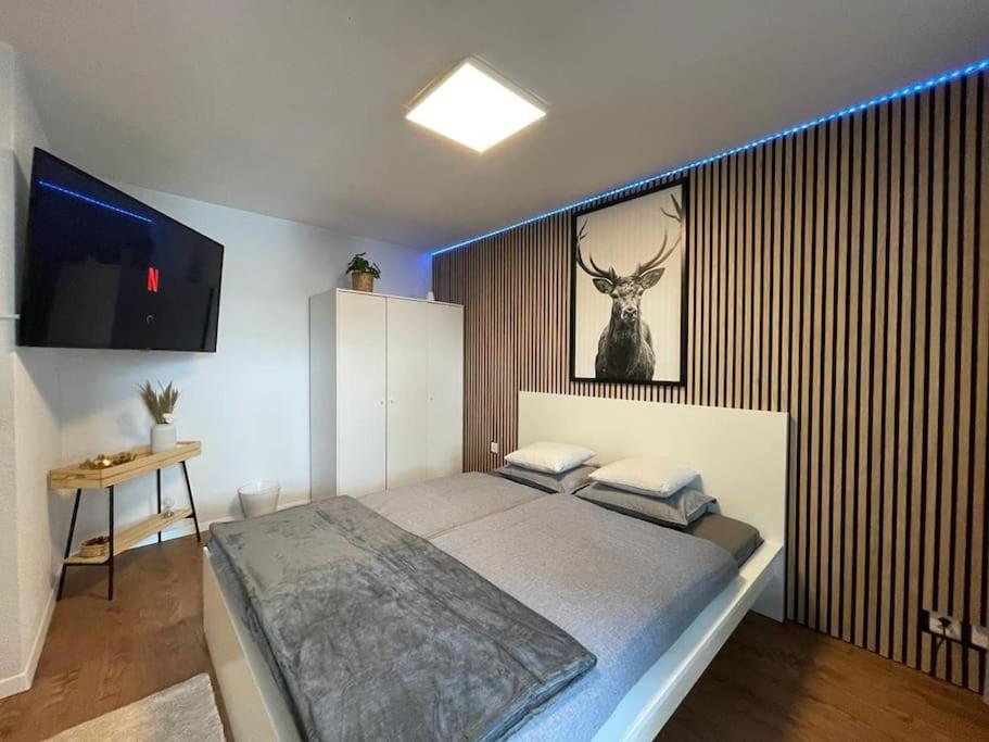 a bedroom with a bed with a picture of a deer on the wall at Relaxing Loft Haven near Zermatt - Parking Free in Täsch