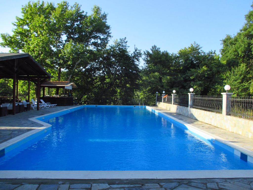 a large blue swimming pool next to a fence at Kotza Ntere in Axioúpolis