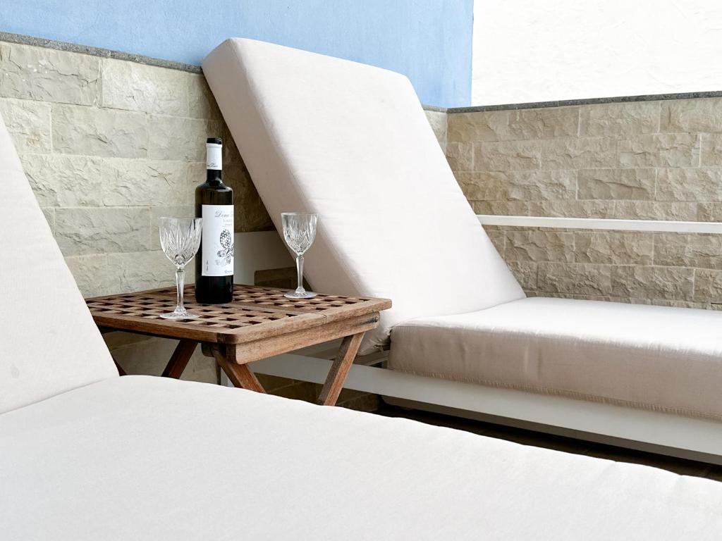 eine Flasche Wein und zwei Gläser auf einem Tisch in der Unterkunft Apartament with private pool and terrace in Mogán