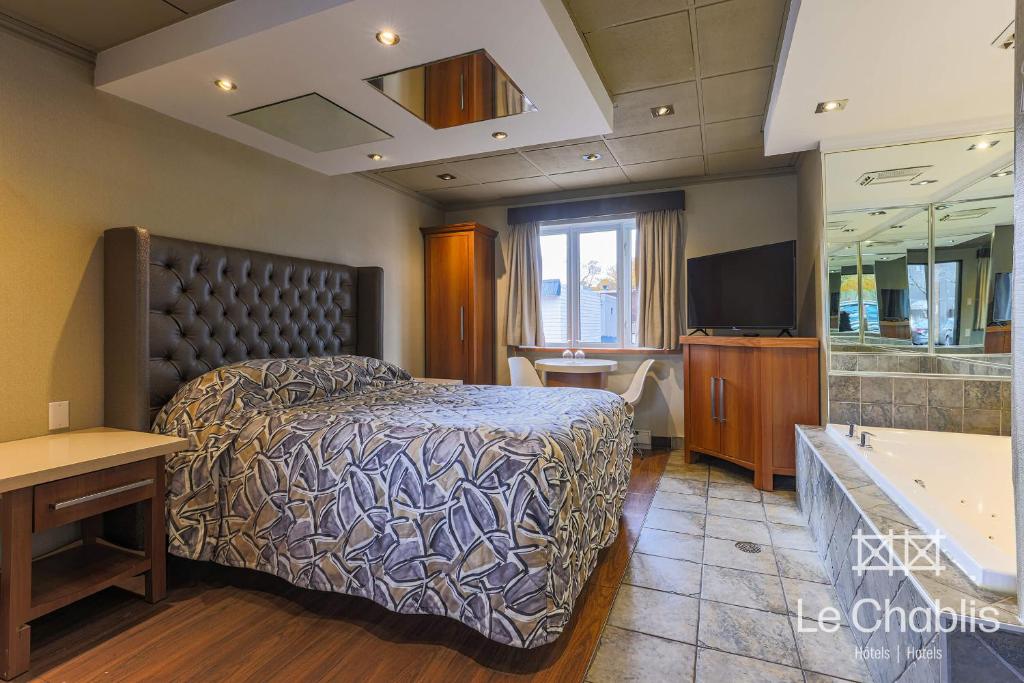 Postel nebo postele na pokoji v ubytování Hotel Le Chablis Cadillac