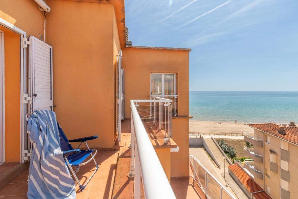 een balkon met een stoel en uitzicht op het strand bij Àtic Brisa Mar in L'Estartit