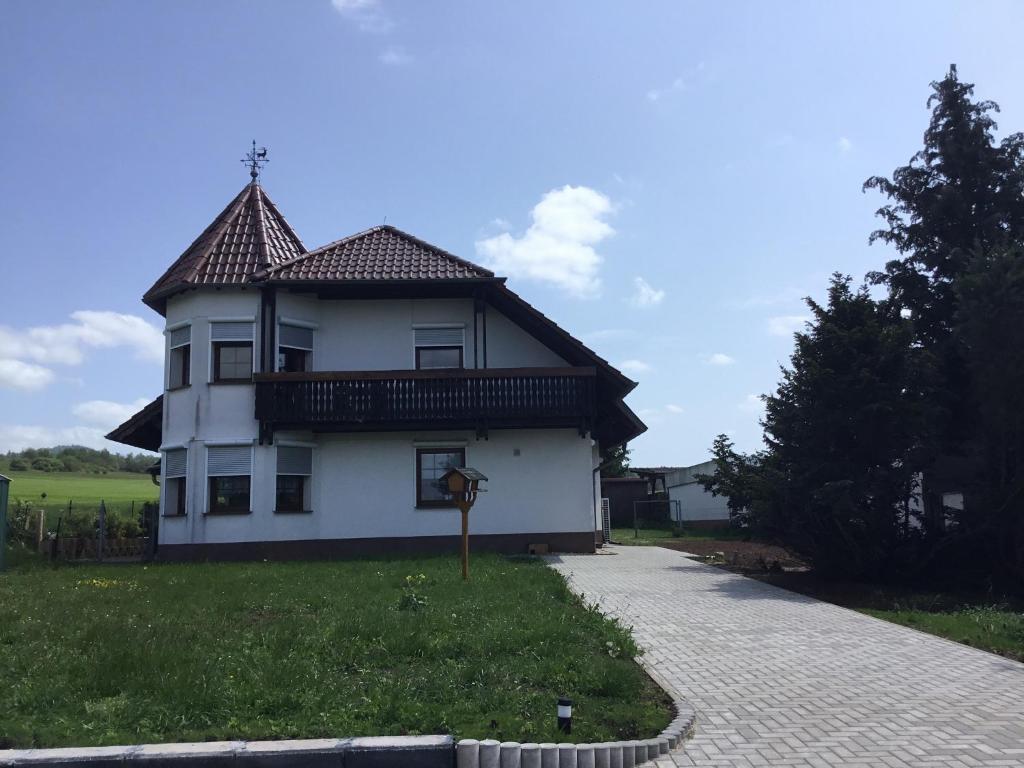 Casa blanca con techo de baldosa en un campo en Ferienhaus Barth, en Bad Salzungen