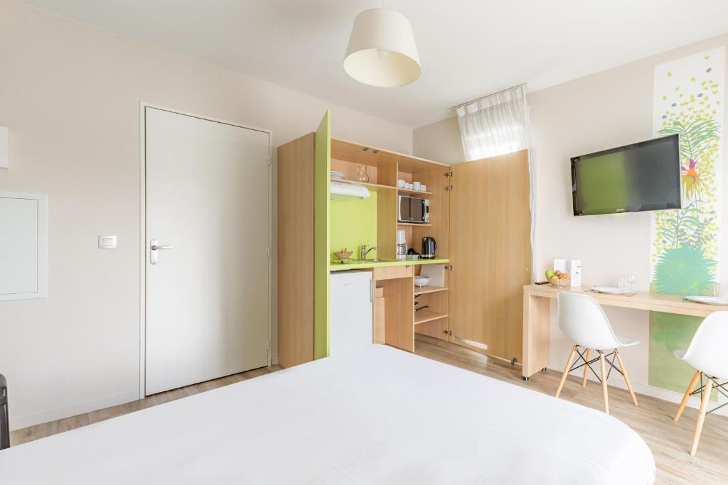 a bedroom with a bed and a desk at Appart’City Confort Tours in Tours