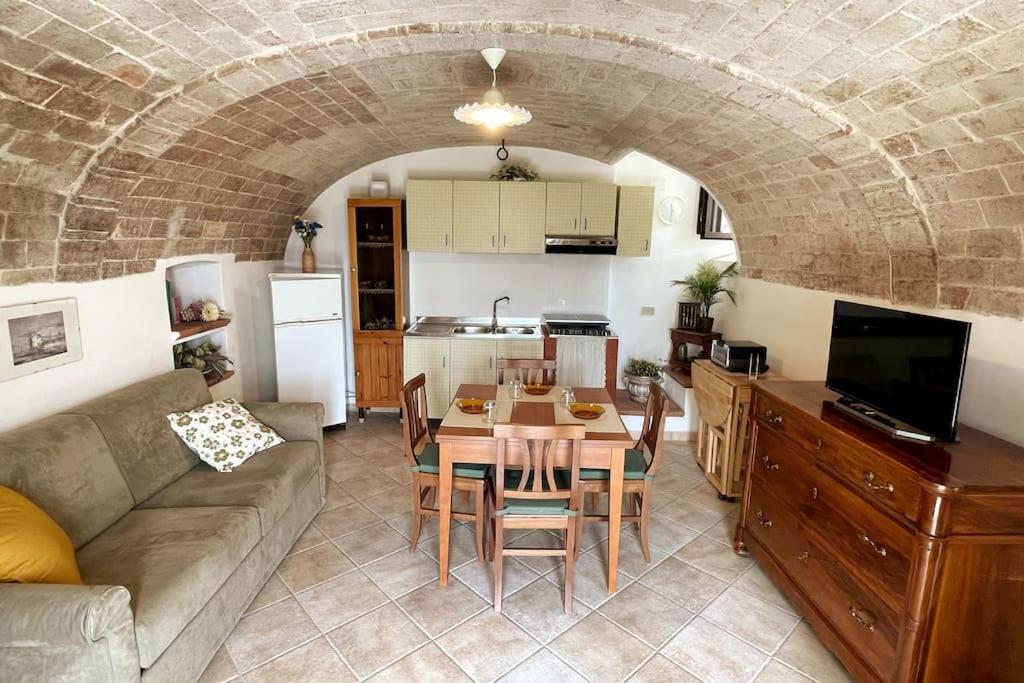 cocina y sala de estar con mesa y sofá. en Nonna Marisa House (In the rock), en Ofena