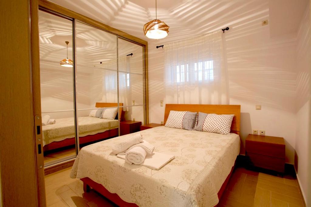 um quarto com uma cama e um espelho em Το σπίτι της Άρτεμης em Lepanto