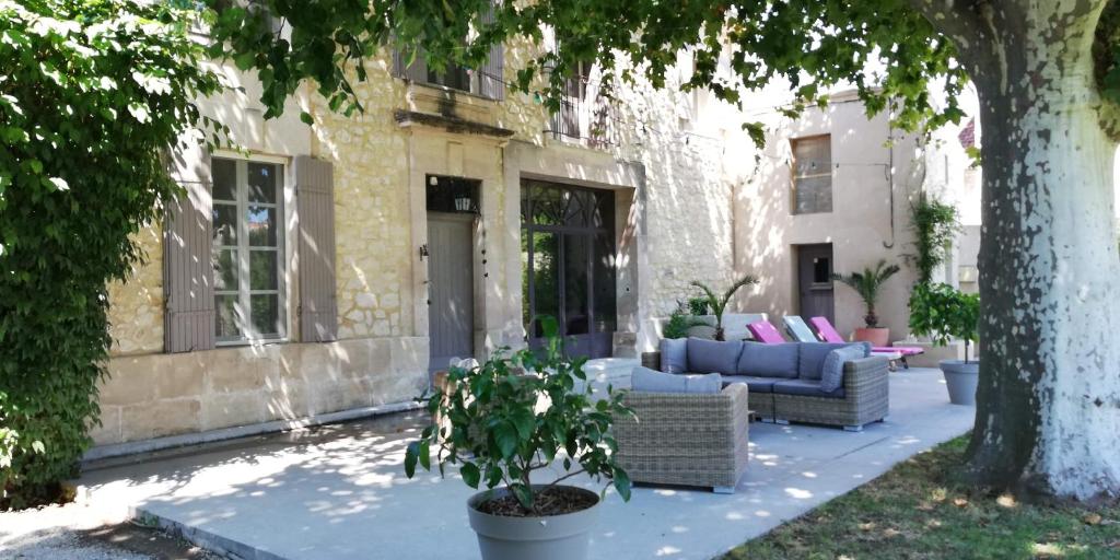 une terrasse avec deux canapés et un arbre dans l'établissement Mas de la Digue, Châteaurenard, 6 chambres, 5 sdb., à Châteaurenard