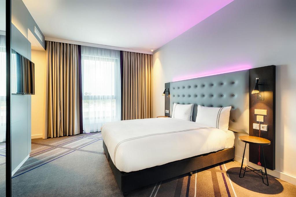 a bedroom with a large bed and a large window at Premier Inn Berlin Airport in Berlin