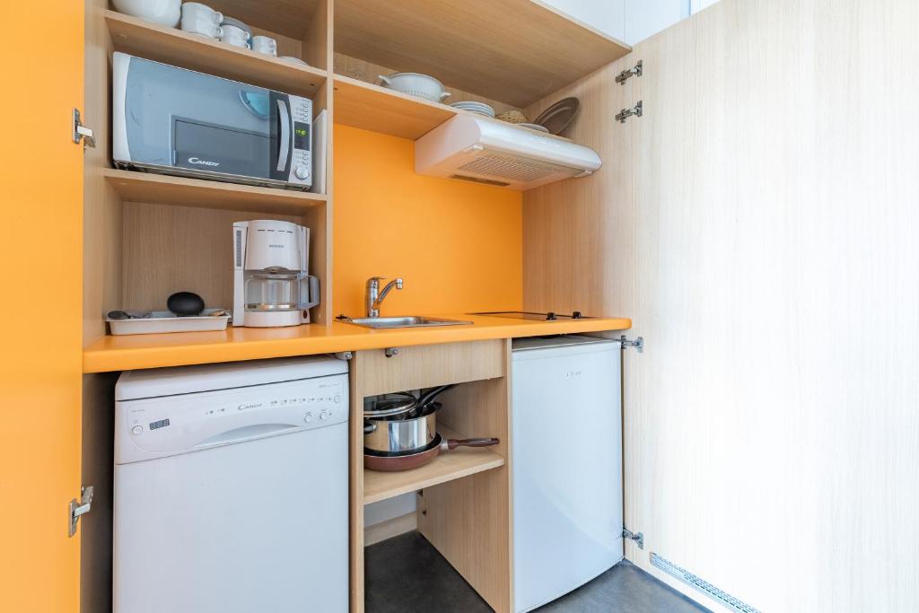 a small kitchen with a sink and a microwave at Appart’City Confort Tours in Tours