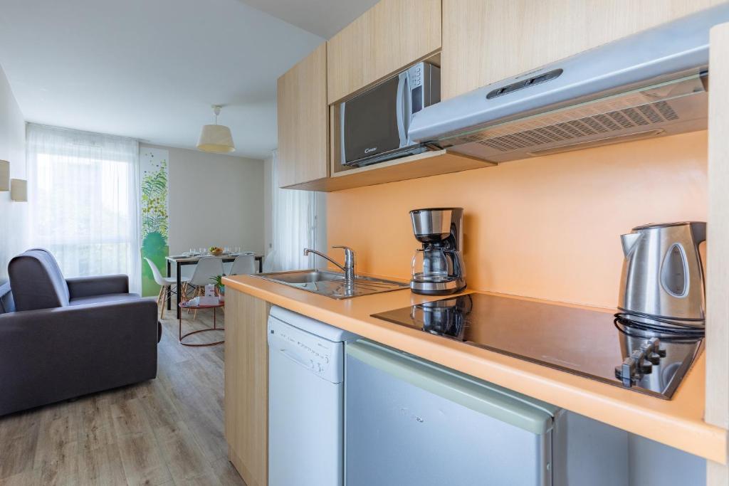 a kitchen with a sink and a counter top at Appart’City Confort Tours in Tours