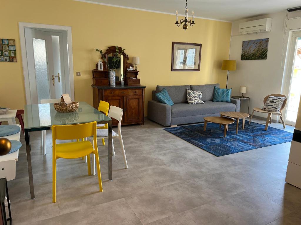 a living room with a couch and a table and chairs at Anfora MitoMare in Grado