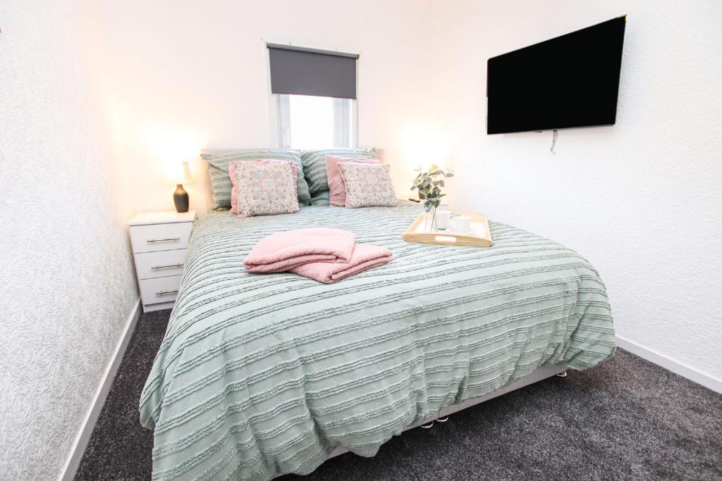 a bedroom with a bed with pink towels on it at Stylish, spacious 3 bed house. Sleeps 7 in Lincoln