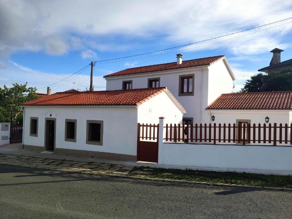 una casa blanca con una valla delante en Albergue Miraiso, en Arzúa