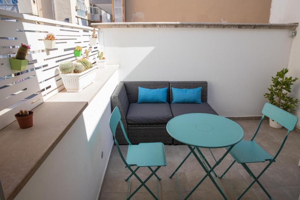 a small balcony with a blue table and chairs at Casa Ginebras in Bari