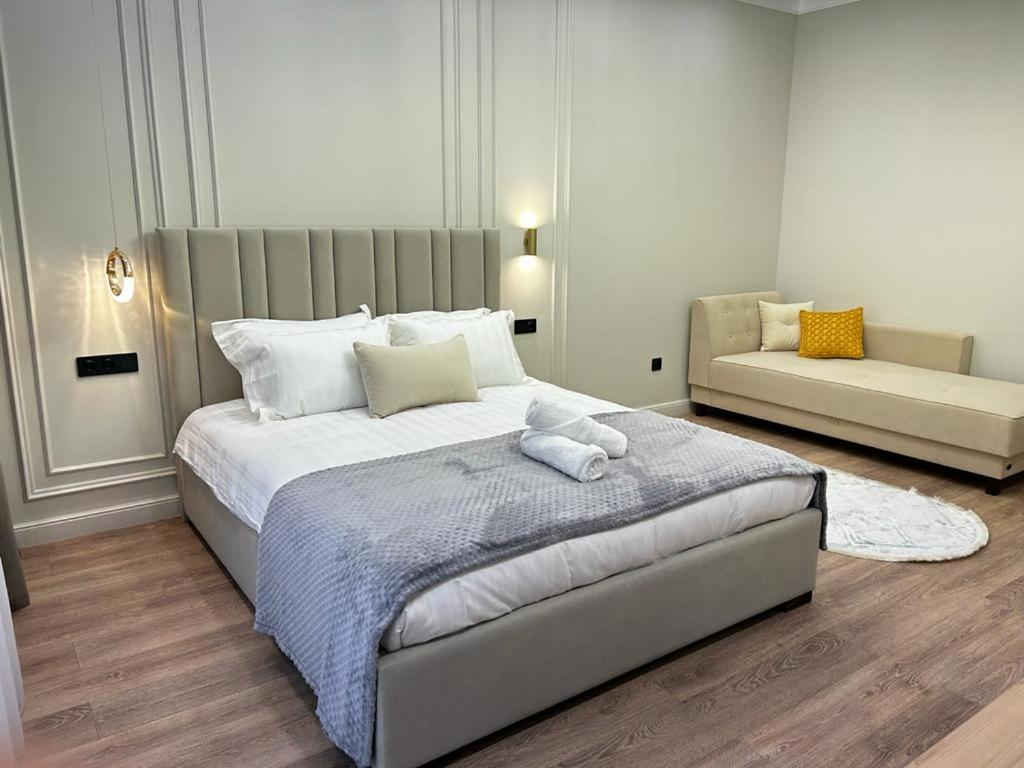 sypialnia z dużym łóżkiem i kanapą w obiekcie Talan life aparts w mieście Atyrau