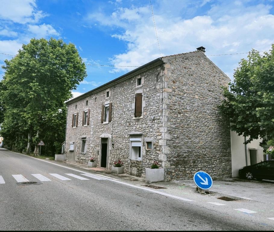 an old stone building on the side of a street at Le Cocon de Mila in Uzer