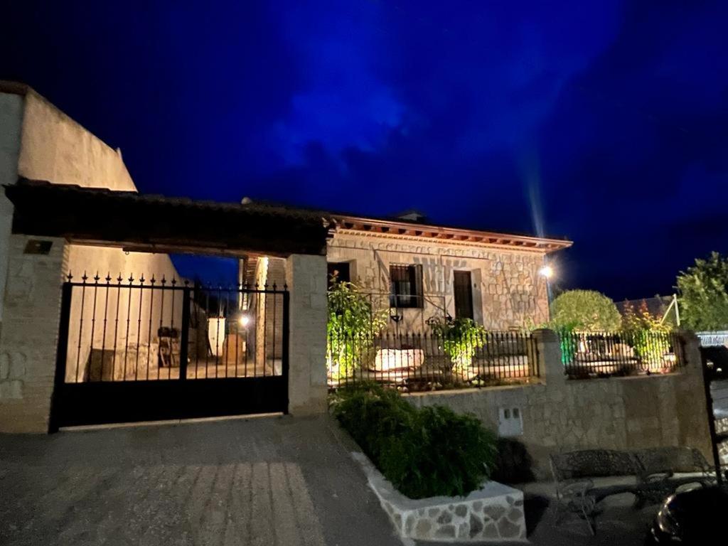 uma casa com uma cerca em frente à noite em Apartamentos Rurales El Pedregoso 