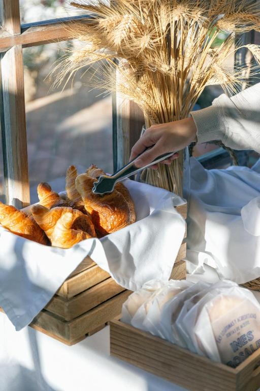 a person holding a spatula over a basket of bread at Hotel Madreselva - Grupo Califa in Los Caños de Meca