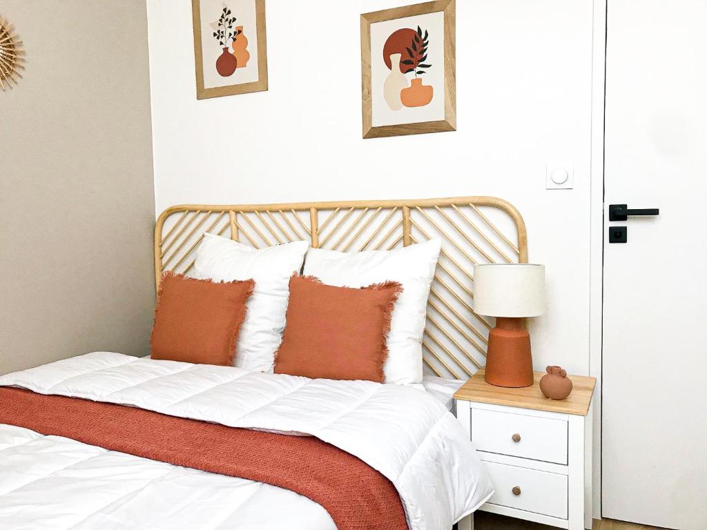 a bedroom with a bed with orange and white pillows at Le provençal - Beau T2 centre ville - Gare - Tram in Le Mans