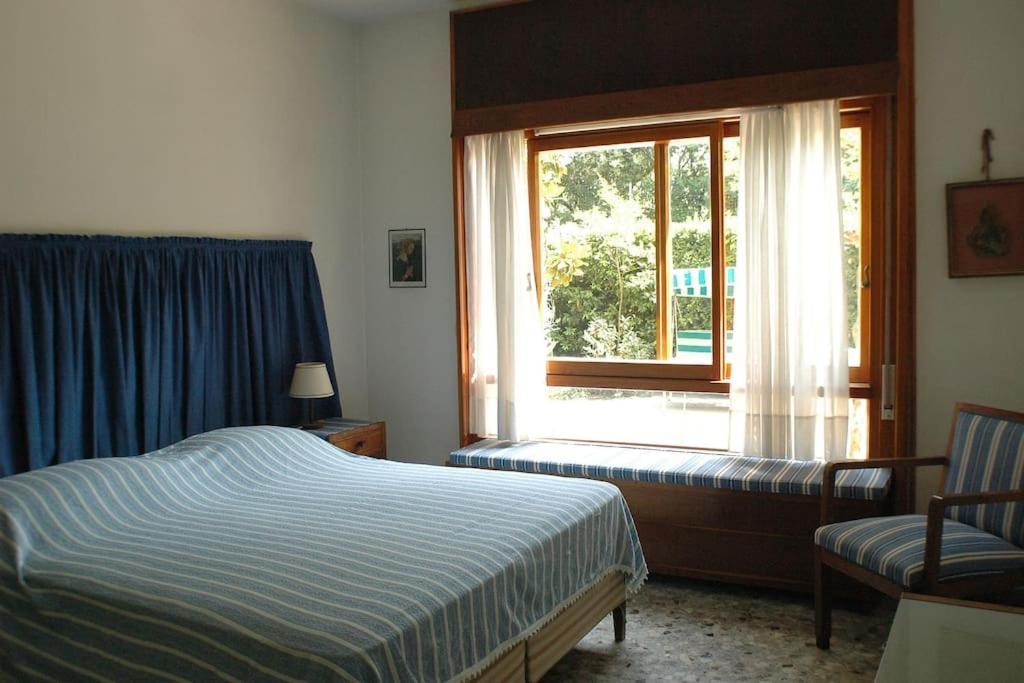 Schlafzimmer mit einem Bett und einem Fenster in der Unterkunft Villa Il Platano con giardino Beachfront in Forte dei Marmi