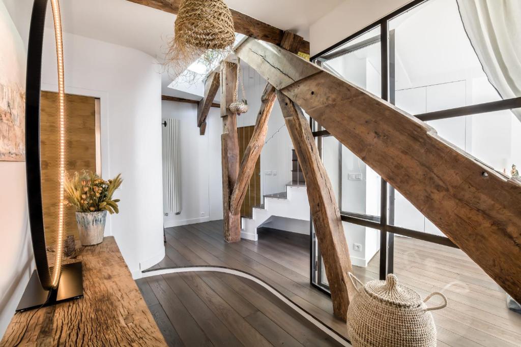 a living room with wooden floors and large windows at Beautiful loft in the 20th district of Paris - Welkeys in Paris