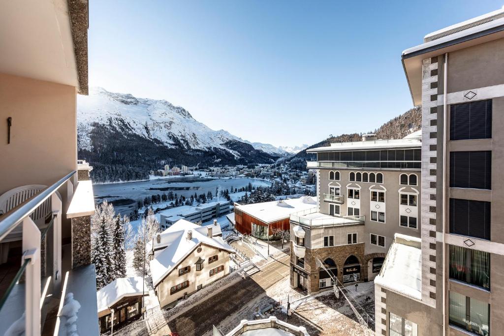 uma vista a partir de uma varanda de uma cidade com montanhas cobertas de neve em Residence Au Reduit Sankt Moritz em St. Moritz