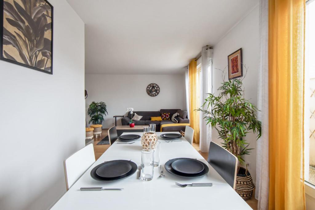 a dining room with a white table and chairs at Charming 2br a 2 steps from the Stade de France - Welkeys in Saint-Denis