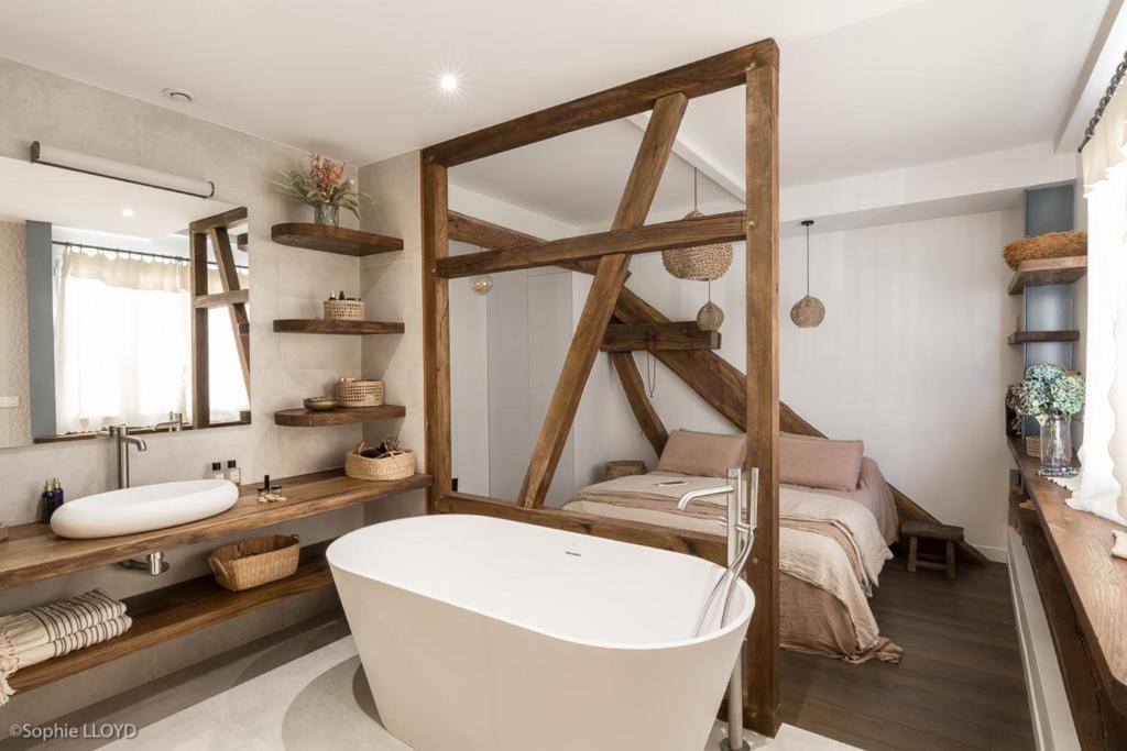 a bathroom with a bath tub and a bed at Beautiful loft in the 20th district of Paris - Welkeys in Paris