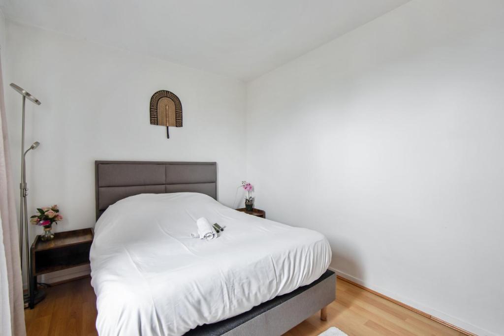 a bedroom with a bed with a white blanket at Charming 2br a 2 steps from the Stade de France - Welkeys in Saint-Denis