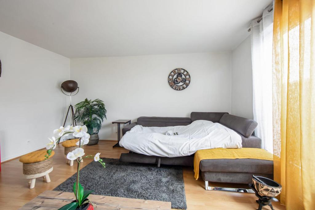 a bedroom with a bed and a couch at Charming 2br a 2 steps from the Stade de France - Welkeys in Saint-Denis