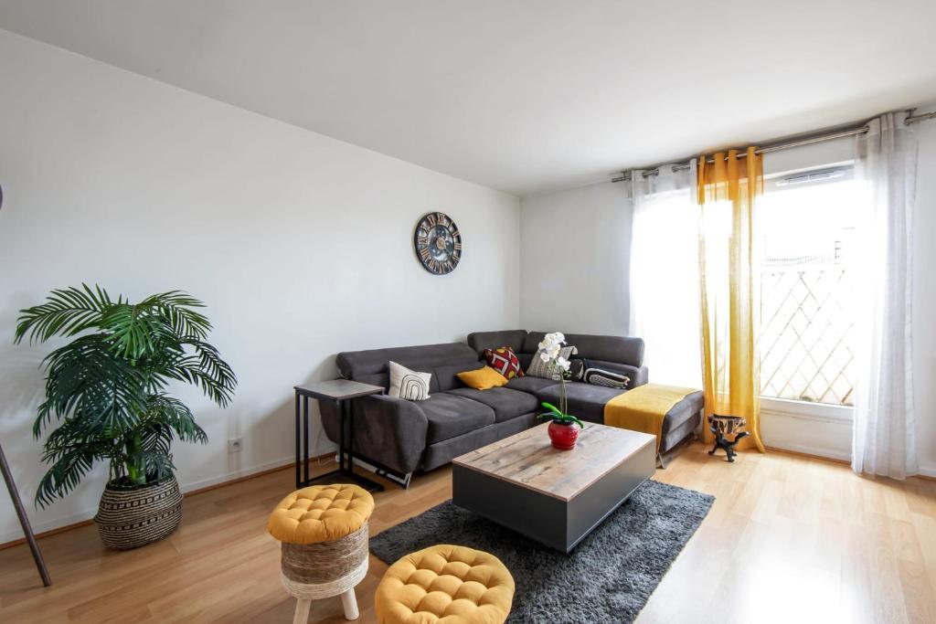 a living room with a couch and a table at Charming 2br a 2 steps from the Stade de France - Welkeys in Saint-Denis
