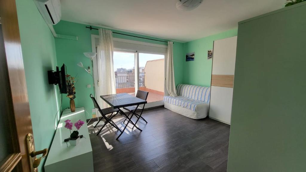 a room with a table and a room with a window at Calella Studio in Calella