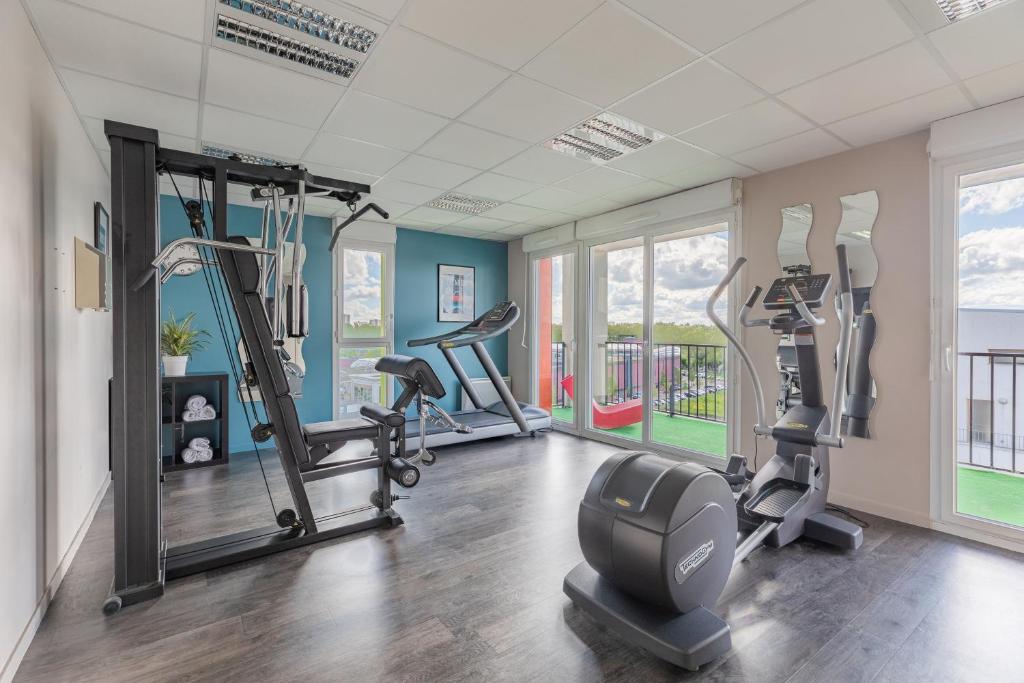 a gym with treadmills and ellipticals in a room at Appart’City Confort Tours in Tours