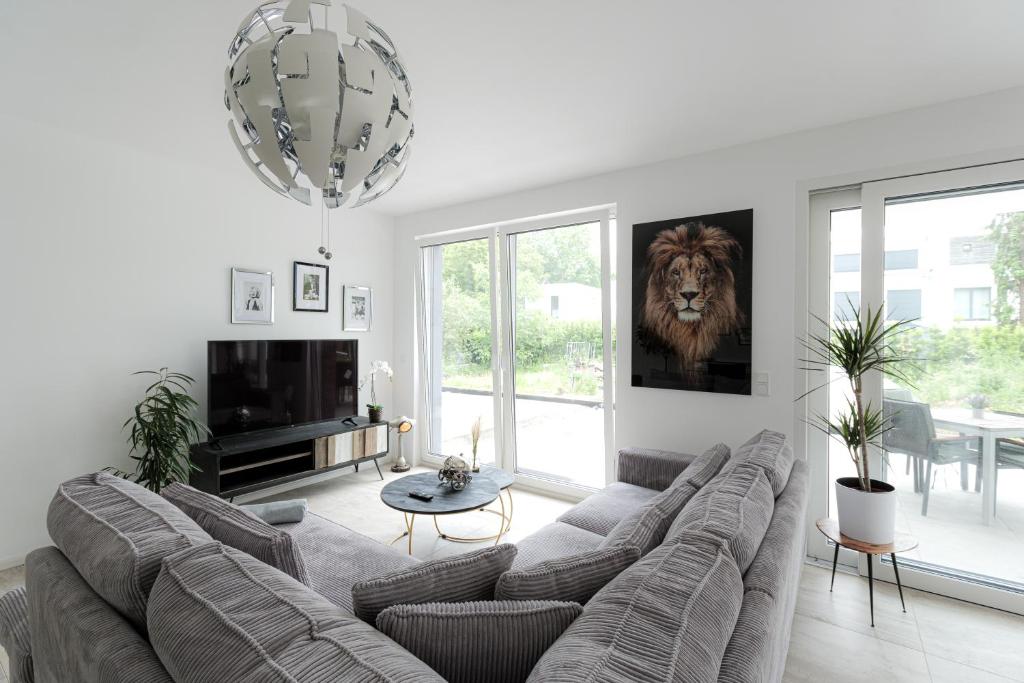 諾伊斯的住宿－LULEX IV - Traumwohnung Terasse Garten in Neuss，客厅配有沙发,墙上挂着狮子画