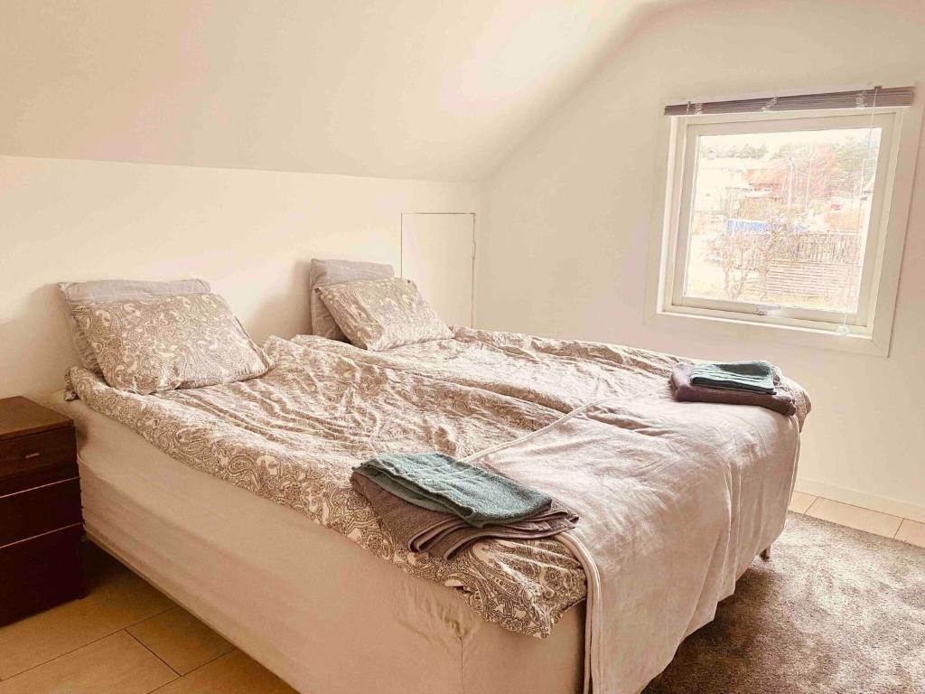 a bedroom with a bed with two pillows and a window at Lovely 3-bed Flat In Stockholm in Sollentuna