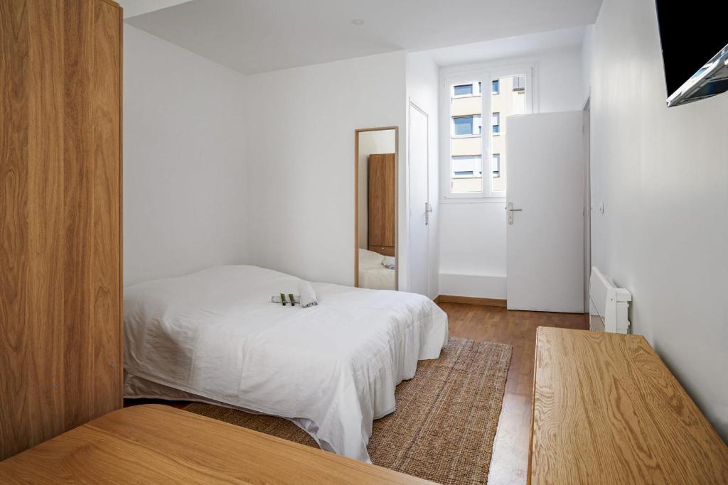 een slaapkamer met een wit bed en een raam bij Nice flat in the 11th district of Paris - Welkeys in Parijs