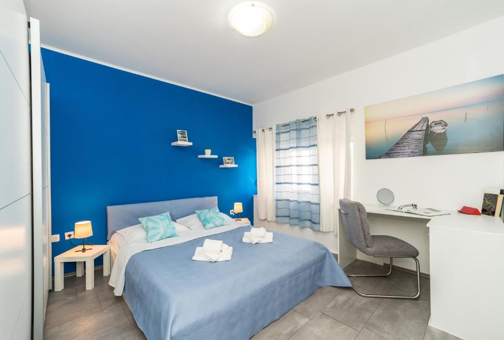 niebieska sypialnia z łóżkiem i biurkiem w obiekcie Apartment Mihaela w mieście Zadar