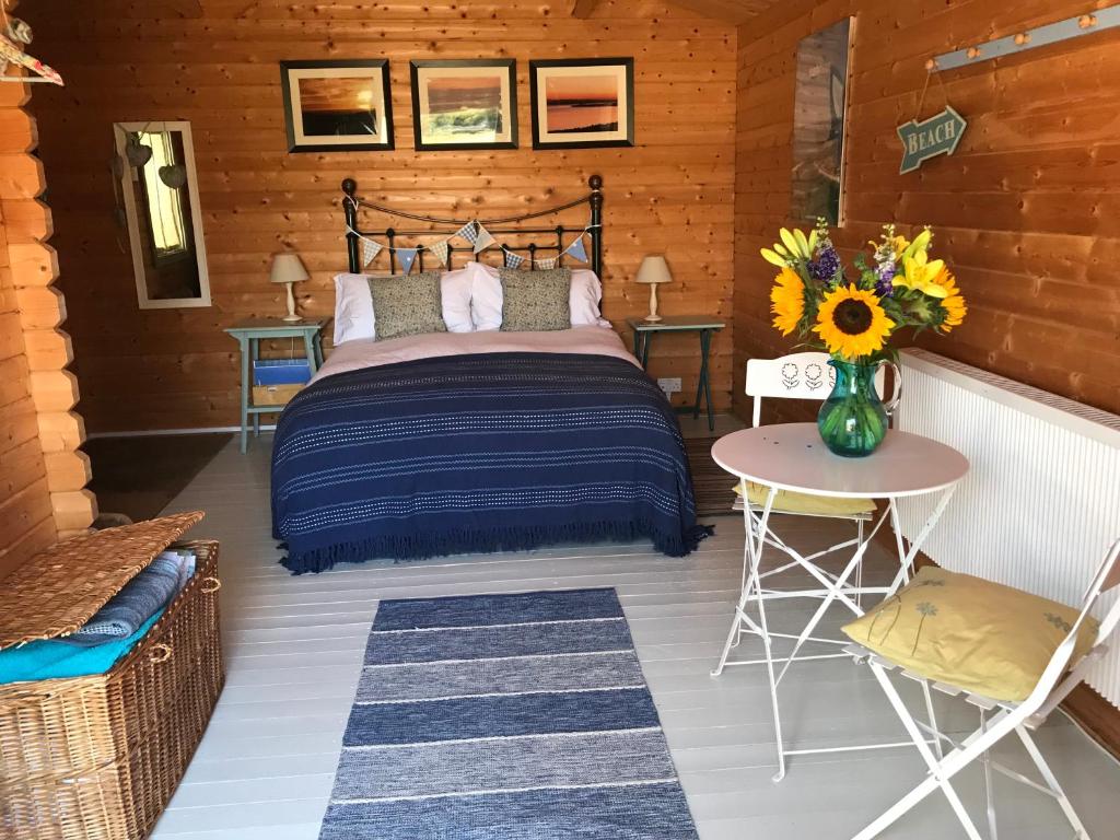 ウィンボーン・ミンスターにあるThe Log Cabinのログキャビン内のベッドルーム(ベッド1台、テーブル付)