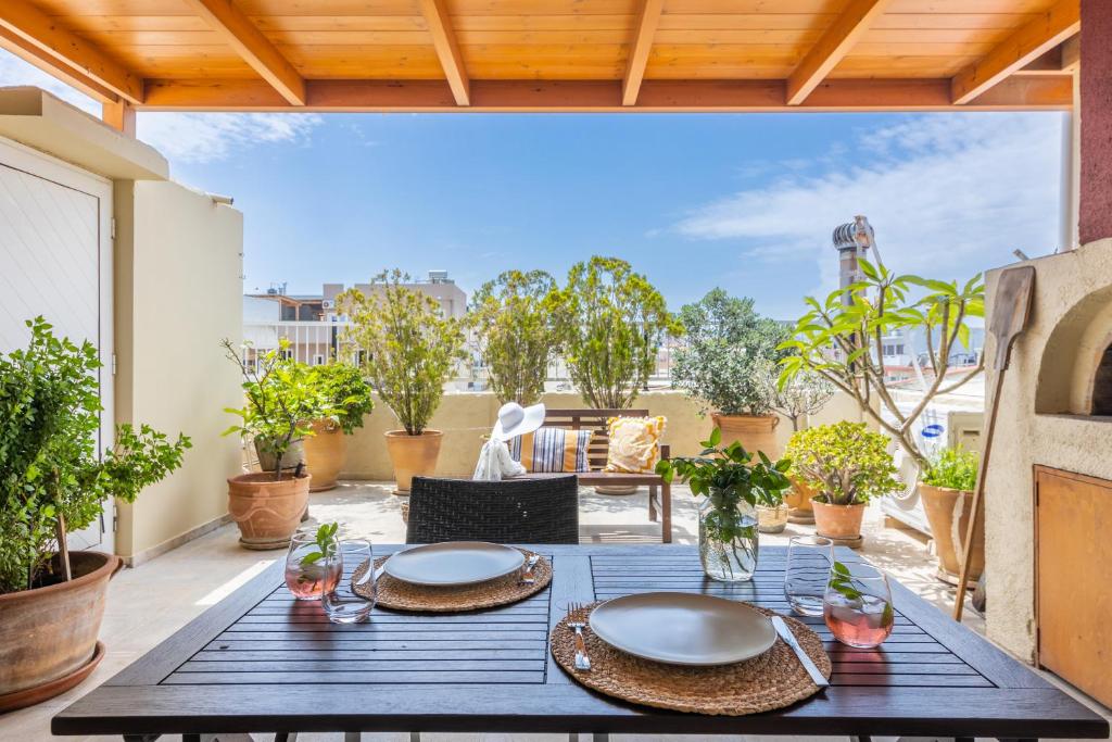 eine Terrasse mit einem Tisch und Stühlen auf dem Balkon in der Unterkunft Doma Rooftop Apartment in Iraklio