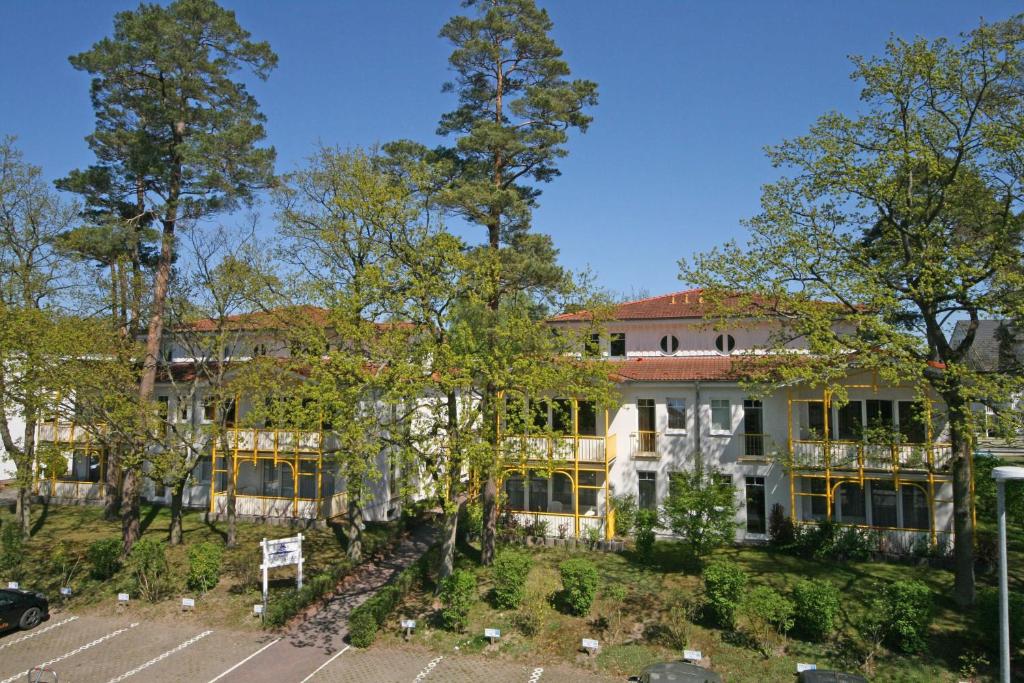 ein großes weißes Gebäude mit Bäumen davor in der Unterkunft Villa Störtebeker - FeWo 05 in Baabe
