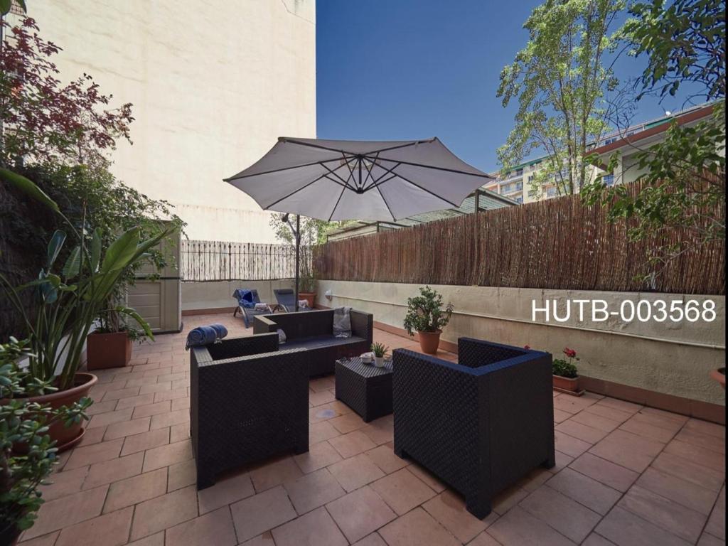 patio con divani e ombrellone di Gran Via Terrace Barcelona a Barcellona