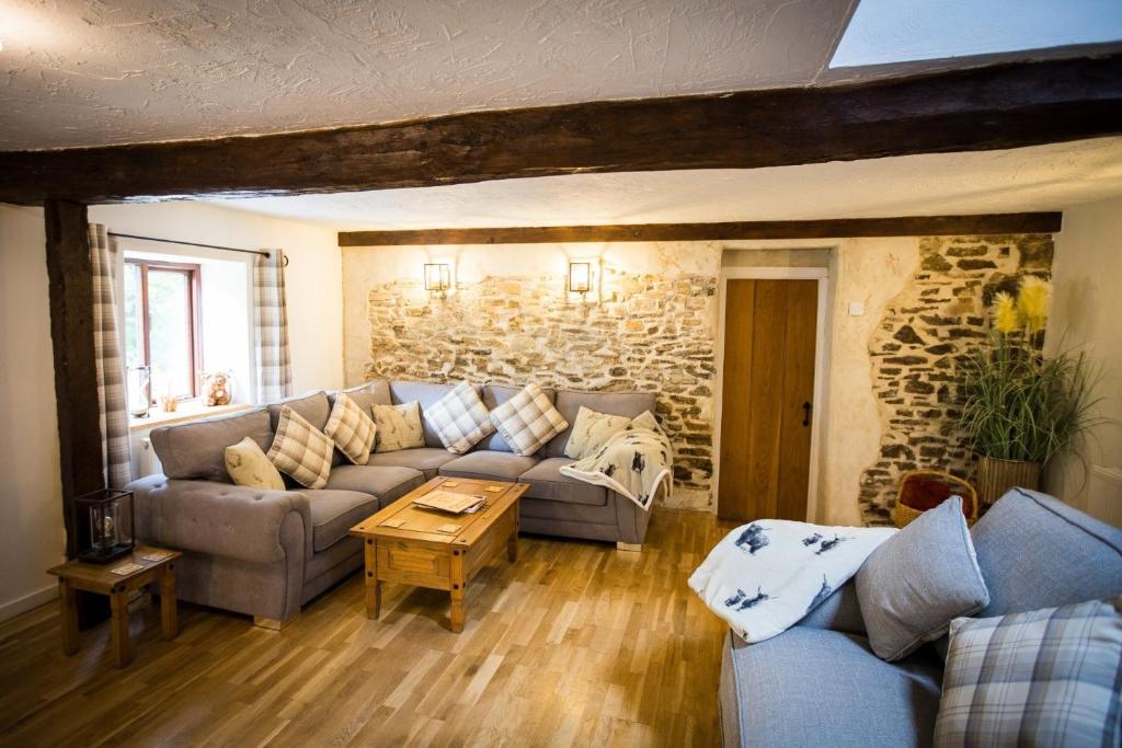 un salon avec un canapé et une table dans l'établissement Warren Cottage at Country Ways, à Atherington