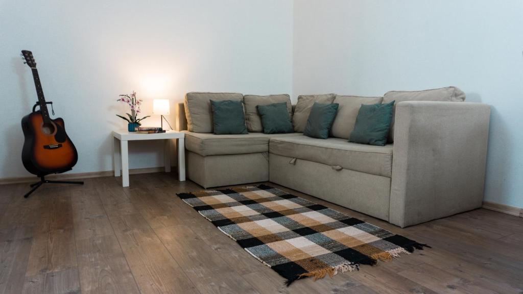 a living room with a couch and a guitar at H22 Apartman in Eger