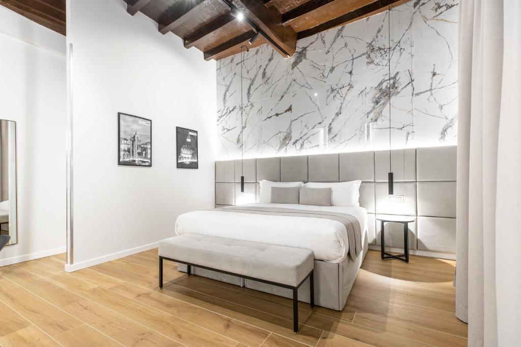 1 dormitorio con 1 cama grande y pared de mármol en Home at Rome Luxury Navona, en Roma