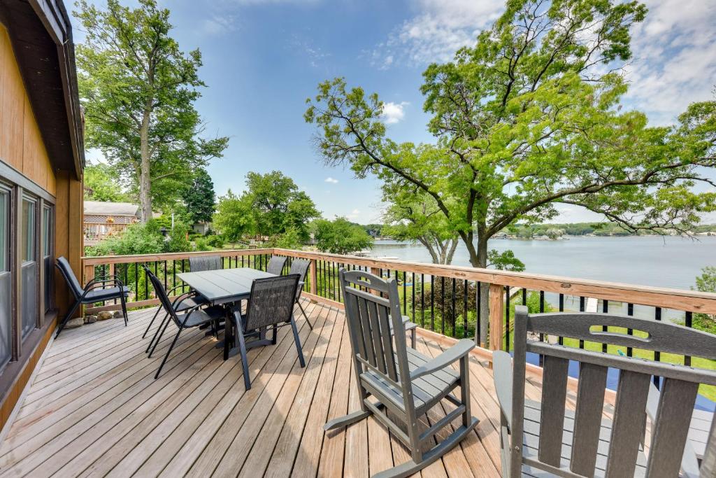 eine Terrasse mit einem Tisch und Stühlen sowie Blick auf das Wasser in der Unterkunft Waterfront Fox Lake Vacation Rental with Fire Pit! in Fox Lake