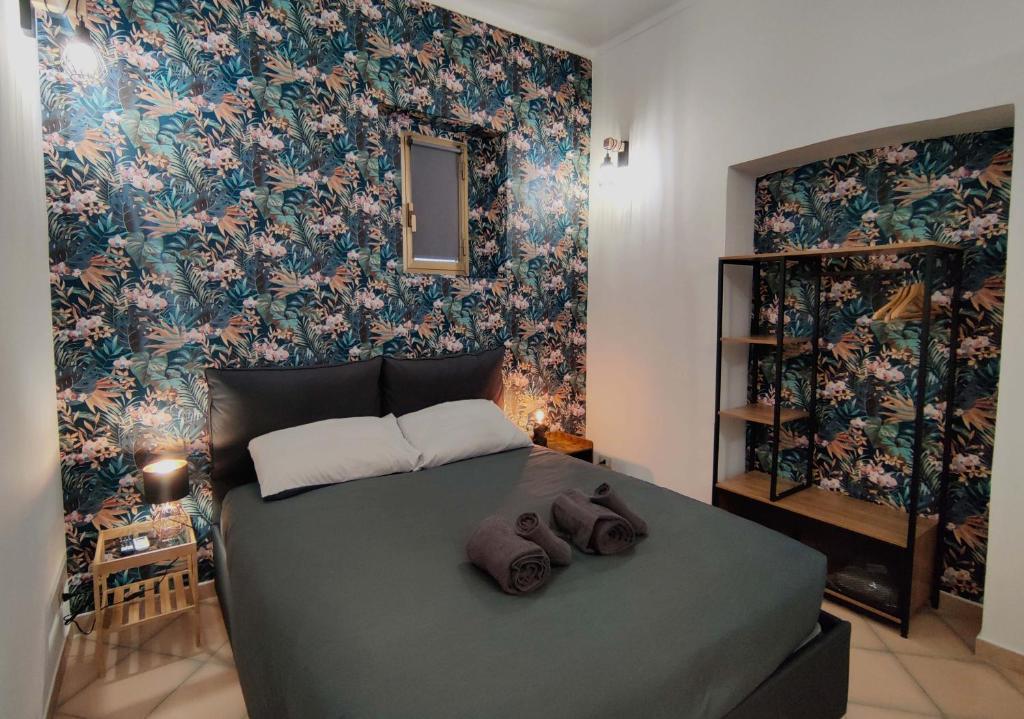 um quarto com uma cama grande e papel de parede floral em Studio Hole - Lingotto em Turim